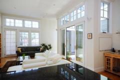 Sunny home interior of open plan apartment showing living room and atrium from kitchen counter