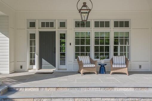 Lantern and chairs decorate this beautiful porch area with wide steps and lots of space