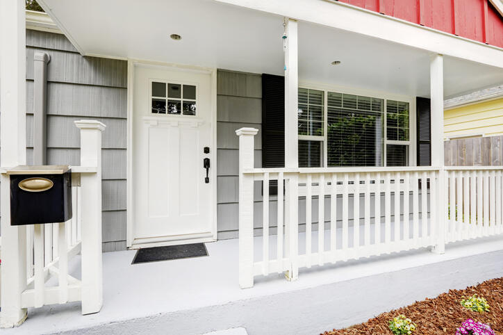 Welcoming front porch boasts pure white front door.