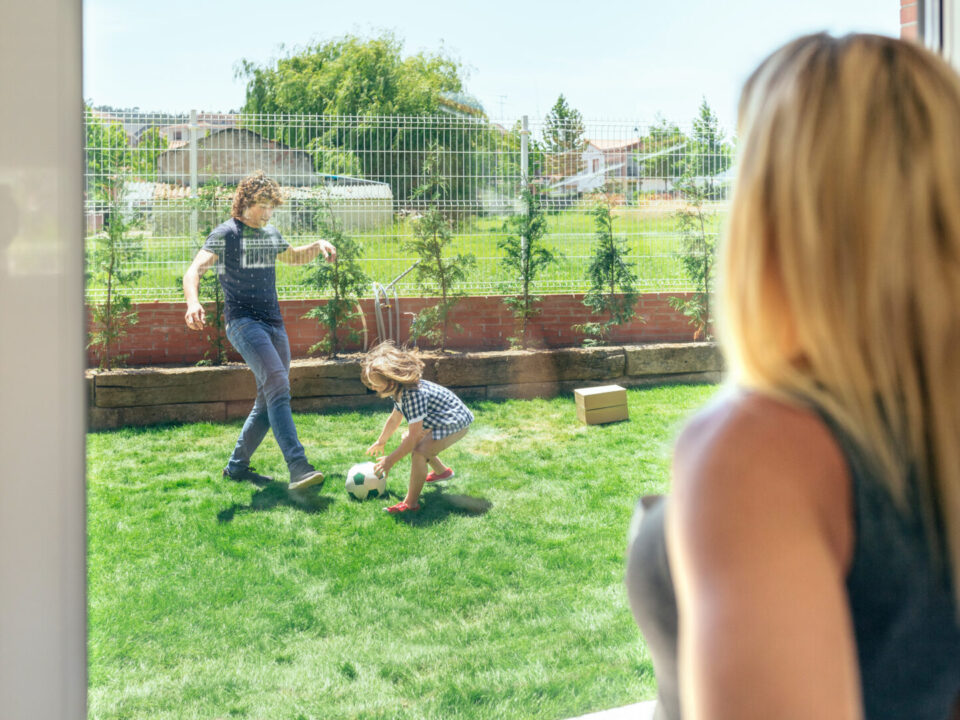 Mother watching her husband and son playing